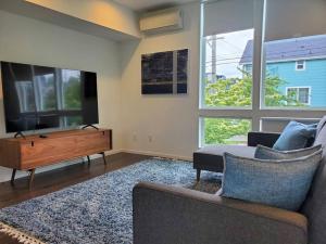 a living room with a flat screen tv and a couch at Modern Townhome Rooftop Deck, Office and King Bed in Seattle
