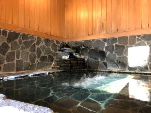a pool in a house with a stone wall at Koguriyama Sanso - Vacation STAY 37452v in Minami Uonuma