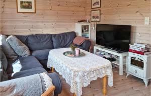 uma sala de estar com um sofá, uma mesa e uma televisão em 3 Bedroom Amazing Home In Vikes em Vikeså