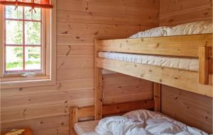 um quarto com 2 beliches num chalé de madeira em 3 Bedroom Amazing Home In Vikes em Vikeså