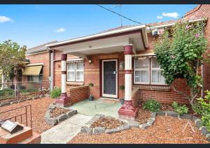 a brick house with a front porch and a door at Comfortable Richmond home - Melbourne’s best location in Melbourne