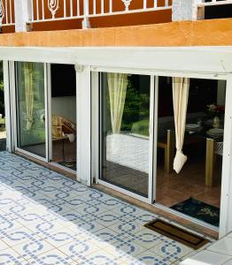 een patio met glazen schuifdeuren van een huis bij Appartement de 2 chambres avec jardin et wifi a Petit Bourg in Petit-Bourg