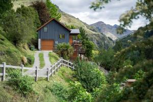a house on the side of a hill with a fence at The Loft at Sixty-7 in Queenstown