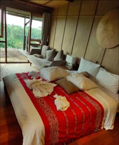 a bedroom with a large bed and a couch at Village Above The Clouds in Bedugul