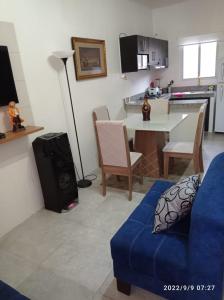 a living room with a blue couch and a kitchen at Villa en Salinas vía Punta Carnero in Salinas