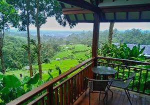 百度庫的住宿－雲上村莊旅館，设有一个配有桌椅并享有美景的阳台。