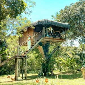 uma casa na árvore com duas pessoas de pé nela em Art Jungle Eco Lodge em Itacaré