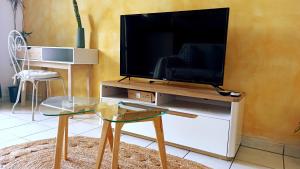 a living room with a television on a stand with a table at Bleu Azur 7 in Saint-Pierre