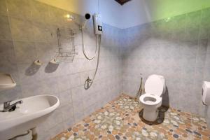 ein Bad mit einem WC und einem Waschbecken in der Unterkunft Hormuenlee resort in Sangkhla Buri