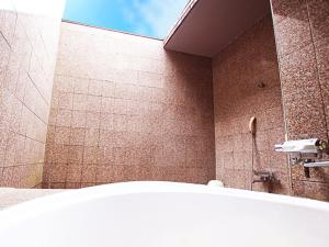 La salle de bains est pourvue d'une douche et d'une baignoire. dans l'établissement フラミンゴ　大人専用, à Yoshioka