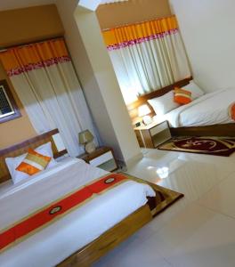 a hotel room with two beds in a room at NAAS Serviced Apartments in Dhaka