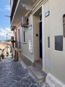 un callejón con un edificio con una puerta azul en Casa 'da Annunziata' few steps from the sea, en Pizzo