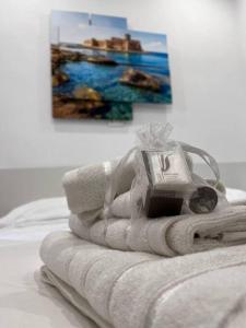a pile of towels on a bed with a painting at Casa 'da Annunziata' few steps from the sea in Pizzo
