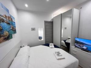 1 dormitorio blanco con 1 cama y TV en Casa 'da Annunziata' few steps from the sea, en Pizzo
