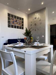 a white table with chairs and a clock on the wall at Casa 'da Annunziata' few steps from the sea in Pizzo