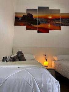 a bedroom with four paintings on the wall at Casa 'da Annunziata' few steps from the sea in Pizzo +30 photos