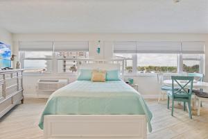 ein Schlafzimmer mit einem Bett, einem Tisch und einem Stuhl in der Unterkunft Beach Views by Day , Star Gazing by Night - Hawaiian Inn Beach Resort in Daytona Beach Shores