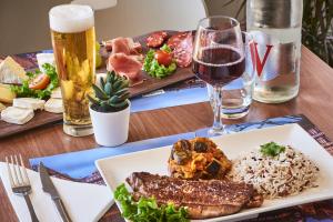 uma mesa com um prato de comida e um copo de cerveja em Kyriad Direct Strasbourg Ouest - Zénith em Estrasburgo
