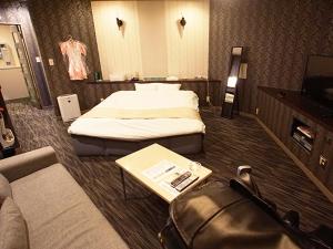 a hotel room with two beds and a couch at グリーンヒル　大人専用 in Yoshioka