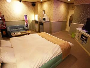 - une chambre à l'hôpital avec un lit et un canapé dans l'établissement グリーンヒル　大人専用, à Yoshioka