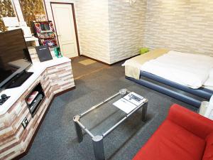 Yoshioka的住宿－グリーンヒル　大人専用，客房设有床、书桌和沙发。