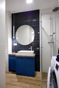 y baño con lavabo azul y espejo. en Apartament Golden View - Rewal Morska 1 en Rewal