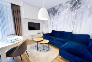 sala de estar con sofá azul y mesa en Apartament Golden View - Rewal Morska 1 en Rewal