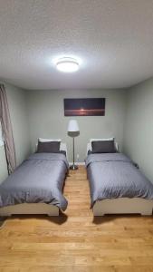 a bedroom with two beds and a lamp at YK Aurora in Yellowknife