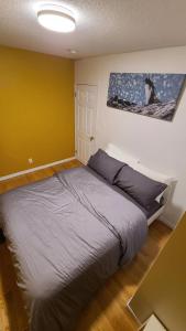 a bedroom with a bed with a painting on the wall at YK Aurora in Yellowknife