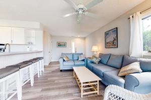 a living room with blue couches and a kitchen at East of the Sun --- 40026 E Sun Dr Unit 611 in Fenwick Island