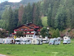 a group of rvs parked in front of a building at Hotel Pontives in Ortisei