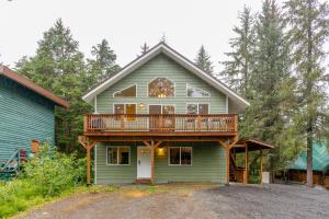 una casa con portico perimetrale e terrazza di AlohAlaska Downstairs Suite a Girdwood