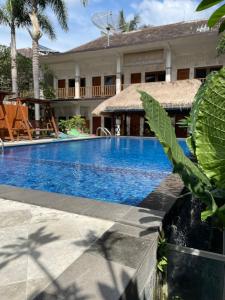 a pool in front of a house with a resort at Central Inn Senggigi in Senggigi