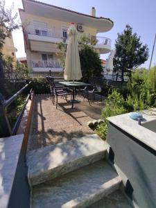 a patio with a table and a umbrella and a building at Fanari Maisonette in Fanari
