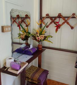 Khao Sok River & Jungle Resort في خاو سوك: غرفة مع طاولة مع الزهور ومرآة