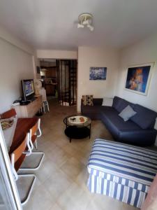 a living room with a blue couch and a table at Fanari Maisonette in Fanari