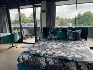 una camera con letto e vista su un balcone di Above and Beyond - luxe suite met sauna en stoomdouche a Zaandam