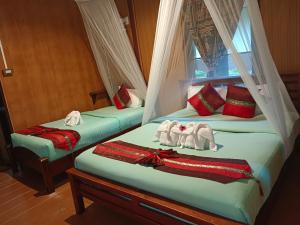 two beds in a room with towels on them at Khao Sok River & Jungle Resort in Khao Sok National Park
