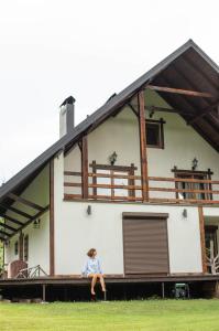 a woman sitting on the porch of a house at Dolyna Mykolaya in Migovo