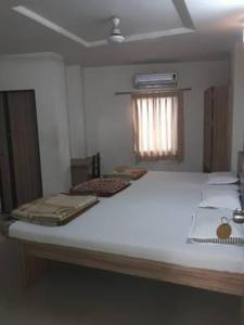 1 dormitorio con 1 cama blanca grande en una habitación en Hotel Pariwar en Aurangabad