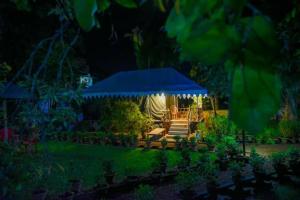 博尔普尔Nibhriti Guest House的凉亭配有长凳和蓝色帐篷