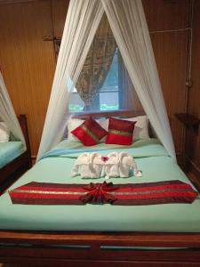 a bed with two towels on it with a window at Khao Sok River & Jungle Resort in Khao Sok
