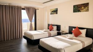 a hotel room with two beds and a window at Navarro Hotel in Caticlan