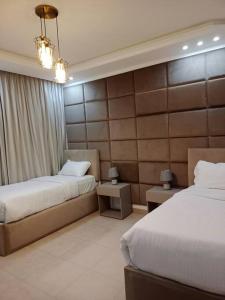 a hotel room with two beds and two tables at Maria Beach Ground Floor Apartament in Aqaba