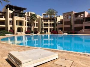 a large swimming pool in front of a building at Maria Beach Ground Floor Apartament in Aqaba