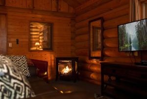 a living room with a fireplace in a log cabin at Lochsa Lodge in Lolo