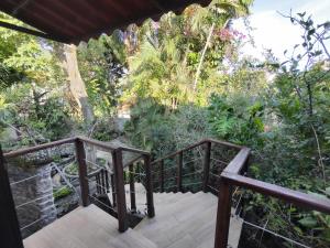 una pasarela que conduce a una habitación con árboles y plantas en La Joyita Cuernavaca, en Cuernavaca