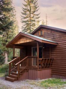Cabaña de madera con porche y terraza en Lochsa Lodge en Lolo