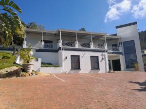 a white house with a brick driveway in front of it at Perle Du Cap in Paarl
