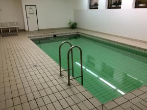 a swimming pool with green water in a building at Walchensee-Idyll in Walchensee